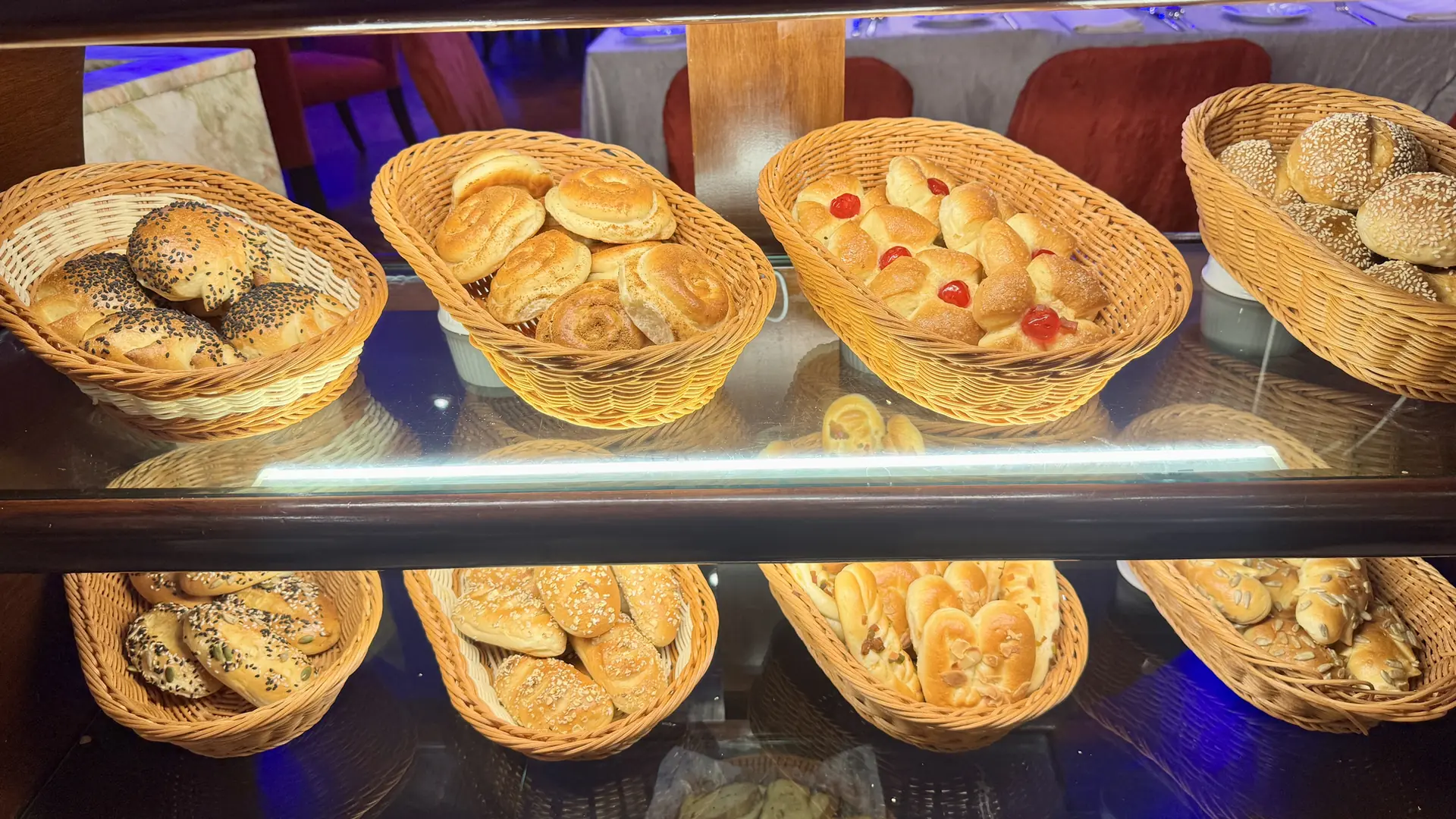 Fresh bread and buns in baskets on a bakery counter